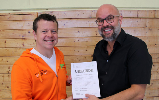 Rektor Johannes Hermann (rechts) und Andreas Herrmann nehmen die Urkunde für die neue Kooperation mit dem TTC Muggensturm und Tischtennis Baden-Württemberg entgegen.